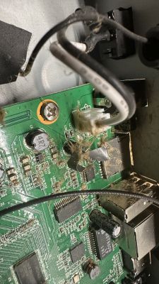 Zbliżenie na płytę główną dekodera Octagon SF8008 z widocznymi uszkodzeniami i zabrudzeniami obok złącza zasilania.
