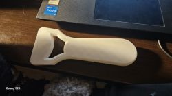 Biały plastikowy przedmiot na biurku obok laptopa.