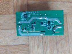 Printed circuit board with electronic components on a wooden surface.