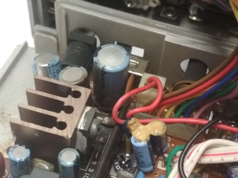 Wnętrze urządzenia elektronicznego z widocznymi komponentami, w tym kondensatorami marki Rubycon i okablowaniem.