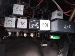 Panel z bezpiecznikami i przekaźnikami w samochodzie, z zauważonym gorącym przekaźnikiem oznaczonym numerem 18.