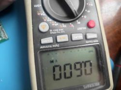 Zbliżenie na multimetr z odczytem napięcia 0,90 V.