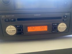 Panel radia samochodowego Nissan z wyświetlaczem FM2 98.1 i przyciskami funkcyjnymi