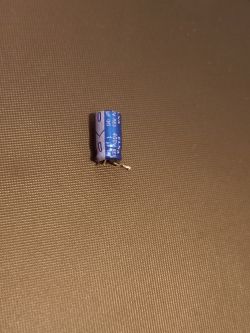 ELNA Electrolytic Capacitor ELNA electrolytic capacitor 1uF 400V on a brown background.