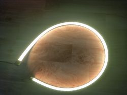 Circular glowing LED strip on a wooden floor.