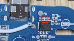 Close-up of an IC and PB3 label on a blue PCB with USB port and soldered wire