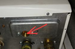 Safety valve on a boiler with a red arrow indicating the outlet.