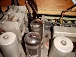 Części starego gramofonu i radioodbiornika lampowego z widocznymi lampami elektronowymi.