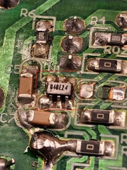 Zbliżenie układu scalonego B048E24 na płytce PCB z uszkodzonymi elementami SMD