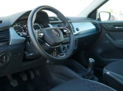 Wnętrze samochodu marki Škoda, widok na kierownicę, deskę rozdzielczą i dźwignię zmiany biegów.