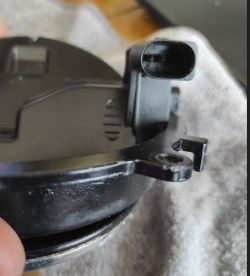 Bliski widok elementu mechanizmu klapki bagażnika samochodowego VW, ukazujący uchwyt i mocowanie.