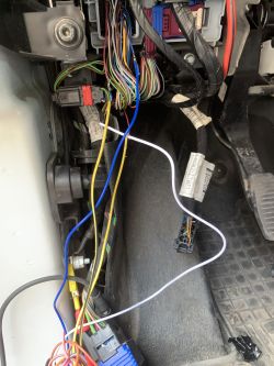 Skomplikowana instalacja elektryczna w samochodzie z widocznymi kolorowymi przewodami i rezystorem.