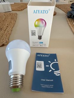Aiyato smart bulb with box and user manual on a table.