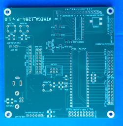 Zielona płytka PCB z białymi oznaczeniami do montażu komponentów elektronicznych.