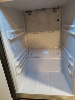 Wnętrze pustej lodówki z widocznymi prowadnicami wzmocnionymi aluminiowymi kątownikami.