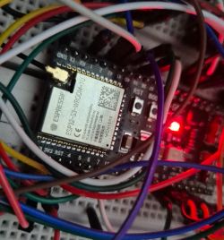 ESP32 module on a board with multiple colorful wires.