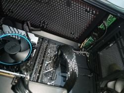 Widok wnętrza komputera, pokazujący płytę główną, wentylator procesora Intel i kable podłączone do różnych komponentów.