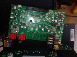 Nahaufnahme einer grünen Leiterplatte mit verschiedenen elektronischen Bauteilen.