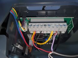 Zbliżenie na połączenia kabli w urządzeniu elektronicznym.