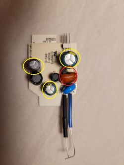 Small PCB with capacitors; parts highlighted with yellow circles and one red circle