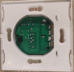 Printed Circuit Board in Mounting Frame Close-up of a printed circuit board (PCB) mounted in a white plastic frame, likely part of an electrical device.
