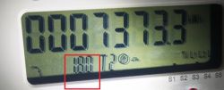 Wyświetlacz licznika energii elektrycznej z podświetlonym kodem 1.8.0 i wskazaniem 7373,3 kWh.