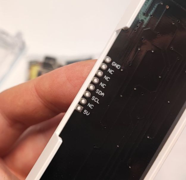 Close-up of the back of a display module showing pin labels: GND, SDA, SCL, and 5V