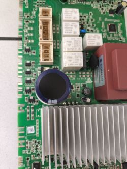 Zbliżenie na płytę główną z przekaźnikami, radiatorami i kondensatorami