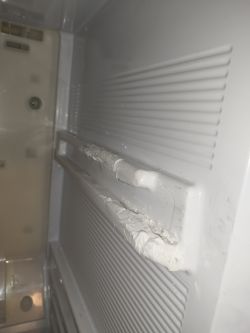 Widok na wnętrze lodówki z aluminiowymi kątownikami wzmacniającymi prowadnice.