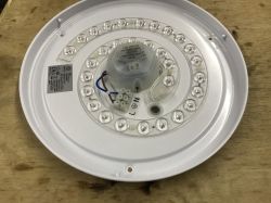 Image of a round LED module on a wooden surface.