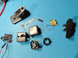 Parts of a Disassembled SQ11 Mini DV Camera Disassembled SQ11 Mini DV camera on a blue background
