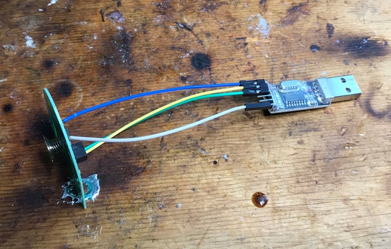 USB-UART converter connected to a CBU board with wires on a wooden table