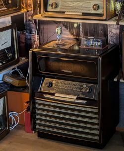 Zabytkowa szafa grająca Grundig 7064/56 w otoczeniu innych retro urządzeń.
