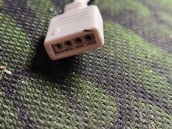 Four-pin Plug Connector Four-pin plug connector on a green surface.