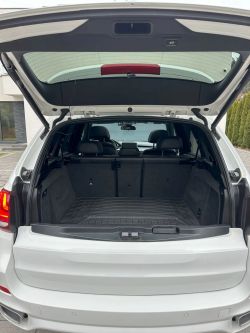 Open trunk of a white SUV with visible rear seat.