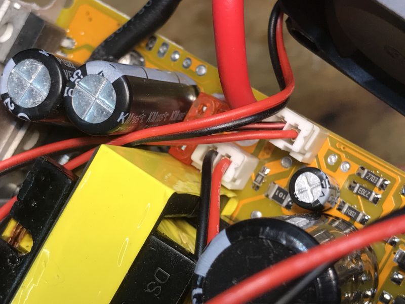Wnętrze przetwornicy samochodowej z widocznymi elementami elektronicznymi i przewodami.