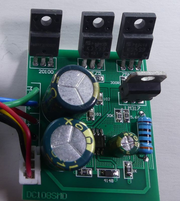Płytka drukowana z elementami elektronicznymi: kondensatorami, tranzystorami i rezystorem.