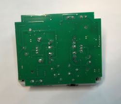 Zielona płytka drukowana (PCB) z widocznymi ścieżkami i punktami lutowniczymi na białym tle.