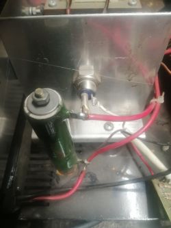Zbliżenie na część elektroniczną z kondensatorem i przewodami.