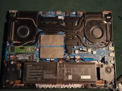 Środek laptopa Asus po modernizacji i czyszczeniu Wnętrze laptopa Asus z widocznym nowym dyskiem SSD Samsung 990 Pro i elementami chłodzenia