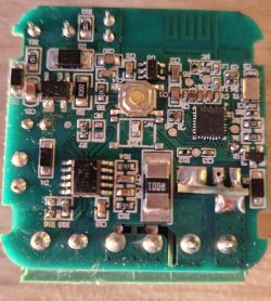 Close-up of a green PCB with SMD components and a printed antenna trace