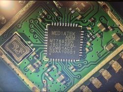 Close-up of a green PCB with a MediaTek MT7682SN chip and a metal resonator can