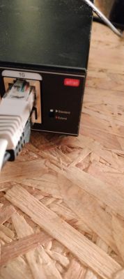 Zbliżenie na port Ethernet switcha PoE z podłączonym przewodem sieciowym