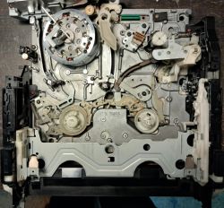 Wnętrze mechanizmu magnetowidu Panasonic NV-HD650 z widocznymi elementami i rolkami.