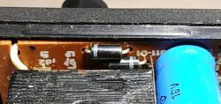 Wnętrze zasilacza Unitra Zatra ZS 0,15/9/2 z elementami elektronicznymi i kondensatorem.