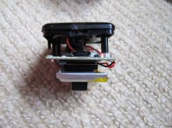 Disassembled Mini Sports Camera on Carpet A disassembled mini sports camera without a case on a light beige carpet.