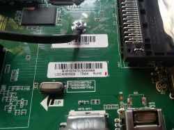 Close-up of a TV motherboard with stickers indicating different models.