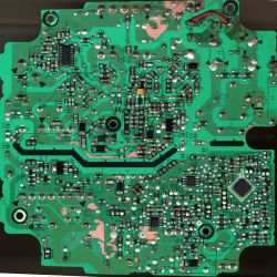 Close-up of a green printed circuit board (PCB) with various electronic components and tracks.