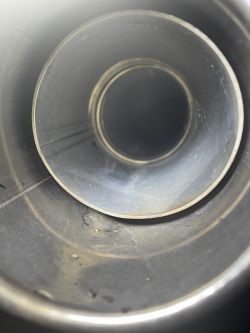 Wnętrze metalowej rury z lekkimi śladami zużycia i zabrudzeniami.
