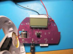 Close-up of a circuit board with an LCD screen and various electronic components.